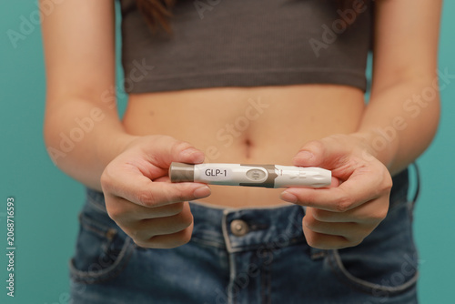 Foto Medical weight management concept with woman holding GLP 1 injection pen in fron