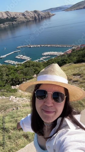 Woman taking selfie above coastal marina
