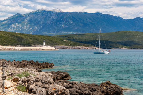 Elegant motor yacht anchored in the crystal-clear turquoise waters of the Adriatic Sea near the rugged coastline
