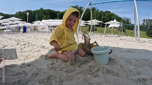 Toddler playing in sand at beach playground