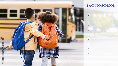 Children walking together with their backpacks towards a yellow school bus, starting a new school year, next to an empty poster with no notes, supply list, or back-to-school text