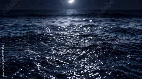 Dark oceanic waves sparkle under bright moon and stars at night creating a serene and moody maritime atmosphere for background use