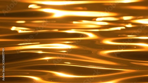 Golden water reflection ripples shimmering fluidly during sunset creating abstract liquid background texture.