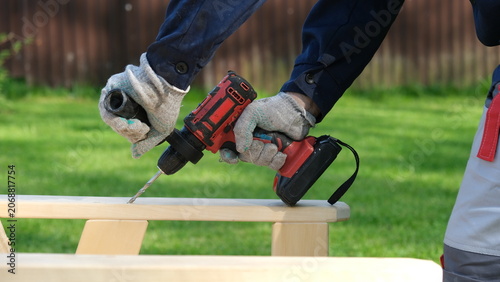 Canvastavla Builder worker using cordless hammer drill