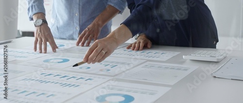 Obraz na płótnie Professional team analyzing financial reports, sharing insights and planning strategic decisions in modern workplace setting