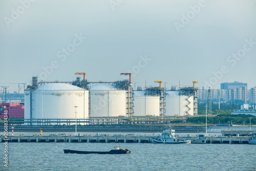 Large industrial storage tanks at waterfront energy terminal in Shanghai, China. Modern fuel storage and logistics infrastructure, energy distribution, maritime transportation, industrial operations