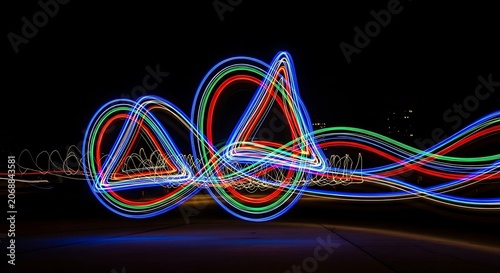 Abstract light trails forming geometric shapes with vibrant colors at night