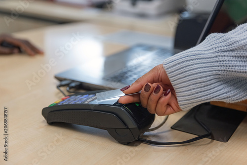 Customer pays for service using contactless credit card on a POS terminal.
