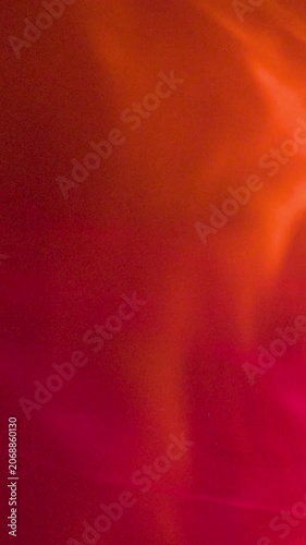 Abstract Slow Motion Red and Orange Ethereal Smoke Background. Flowing Glowing Fluid Texture with Warm Light
