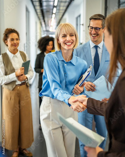 Businesswomen shaking hands making a partnership deal in office