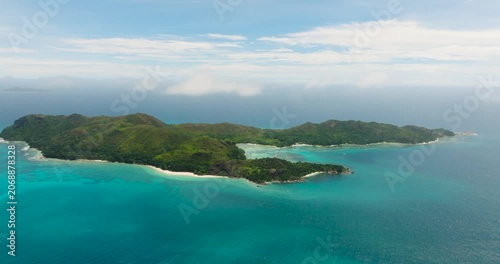 Aerial view of an island featuring lush greenery and turquoise waters against the expansive ocean. Curieuse island, Seychelles.