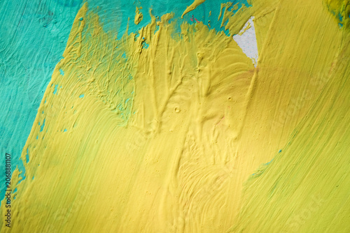 Macro texture of yellow and turquoise acrylic paint on canvas