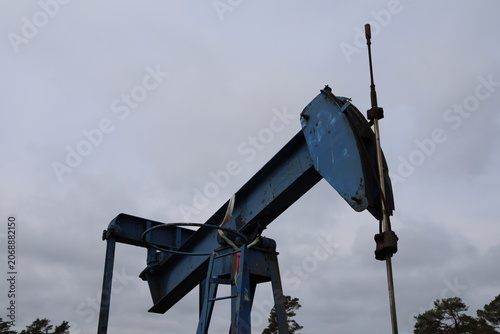 Historic oil pump at the Rute oil field on Gotland, Sweden, photographed in bright summer daylight. A preserved industrial heritage site reflecting Sweden's former onshore oil production.