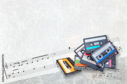 audio cassettes and musical score on light gray background