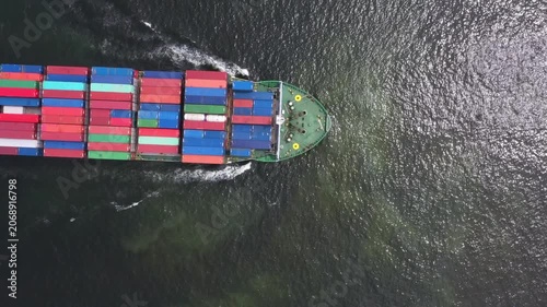 Large container ship traverses dark ocean waters, transporting cargo containers across international trade routes-dynamic view of global shipping operations and maritime industry logistics.