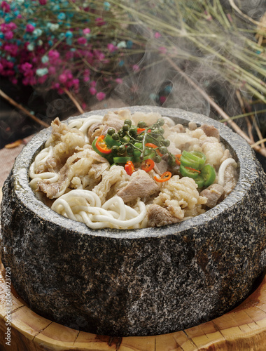 Sour Soup Beef in a Stone Pot Placed on a Wooden Stool
