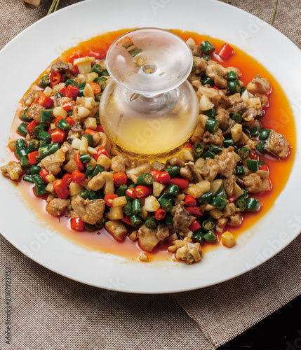Champagne-flavored braised rabbit with rice peppers, served on a white porcelain plate