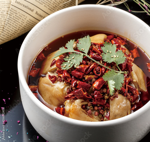Spicy pig's trotters served in a round white soup bowl