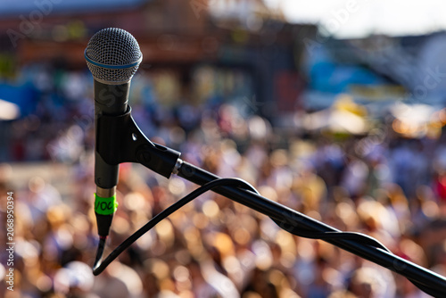 rofessional vocal microphone close up on live concert stage with blurred crowd background