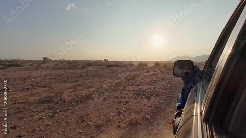 Car ride on dusty road at sunset
