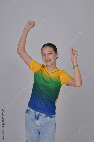 adolescente engraçada torcedora do brasil usando cores verde e amarelo