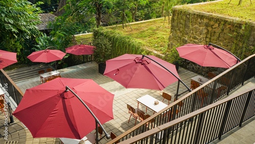 Konstfotografi Red patio umbrellas overlooking terraced outdoor seating area