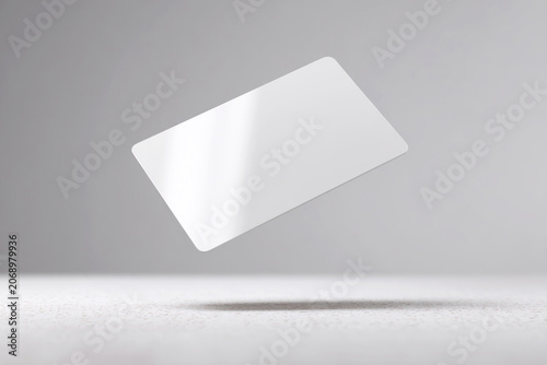 Blank white credit card mockup floating in a minimalist gray studio scene