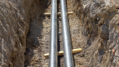 Foto Parallel preinsulated heating utility pipelines laid inside deep earthen constru