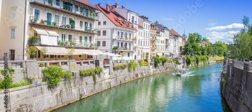 Panorama of a tourist boat along colorful embankments of the river in Ljubljana, Slovenia