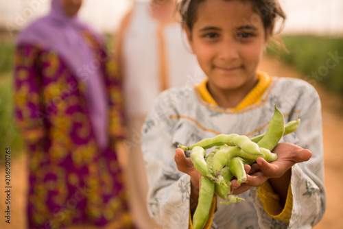 Photos Proud young Middle Eastern girl child farmer wearing traditional white embroider