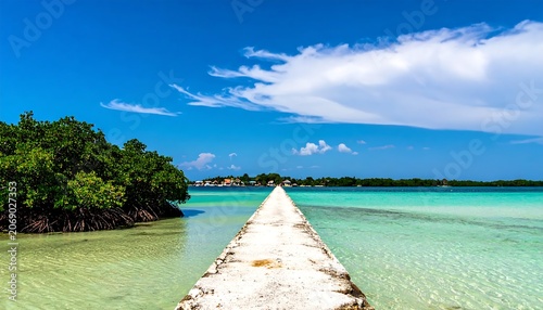 Long Concrete Pier Extending Across Clear Turquoise Lagoon Under Bright Blue Sky