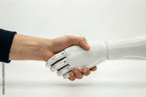 Close Up of Human and White Robotic Hand Shaking Hands on Plain White Background for Artificial Intelligence Business Cooperation and Human Machine Partnership Concept