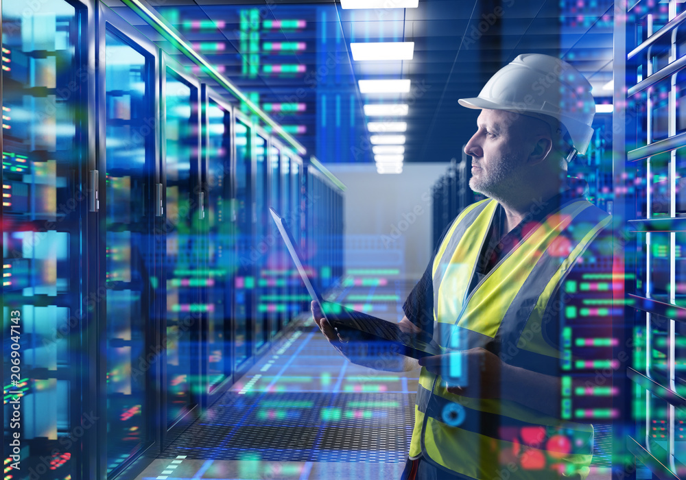 Fototapeta premium Data center operation. Engineer monitors server racks and network systems using laptop inside secure cloud infrastructure facility