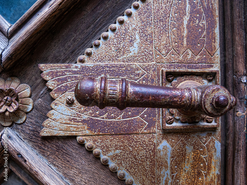 Rusty door handle on wooden door in Chernivtsi, Ukraine showing intricate designs and textures
