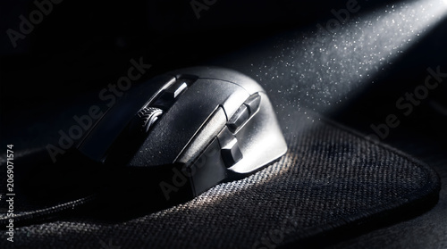 Gaming Mouse with Dust Particles in Spotlight on Mousepad.