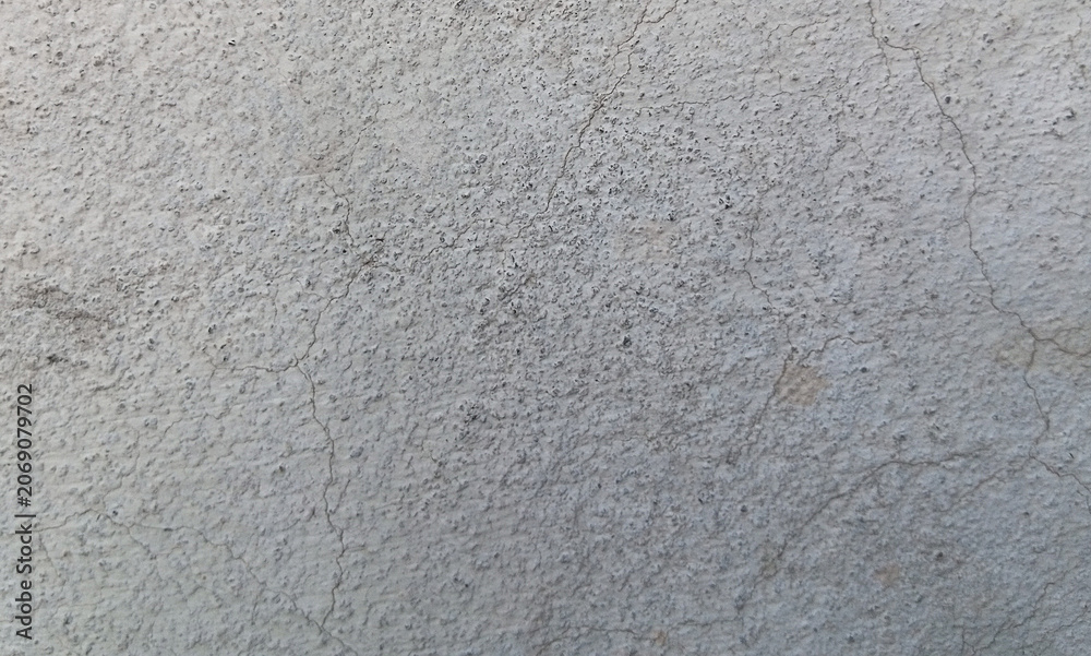 Fototapeta premium Grungy concrete wall texture with fine cracks, weathered gray cement surface background, industrial stone plaster material for architectural design