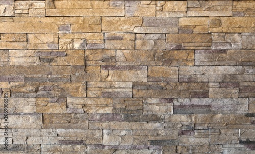 Schilderij op canvas Wall made of reconstructed strips stone with warm tones ranging from beige to ochre, all the way to gray and reddish shades