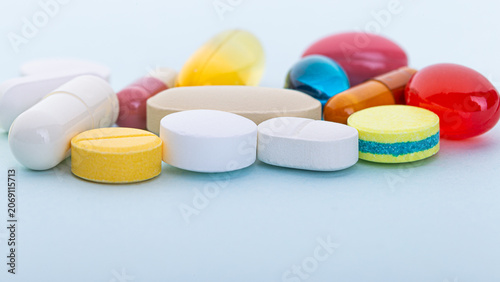 Принти на полотні Assorted tablets, capsules, and softgels arranged on a light blue background