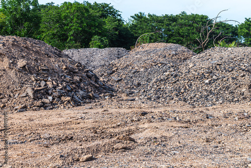 Fotografie Gravel piles at an outdoor construction site with trees in the background