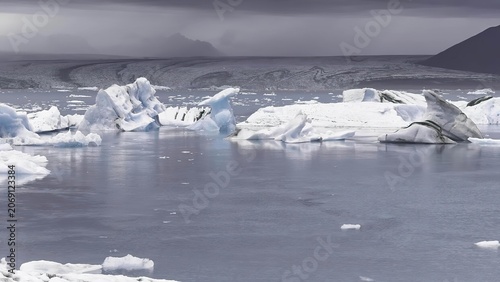 Bild auf Leinwand Melting glaciers floating in icy arctic ocean under cloudy sky