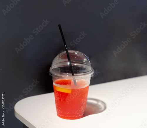Strawberry soft drink with ice cubes and a slice of lemon 