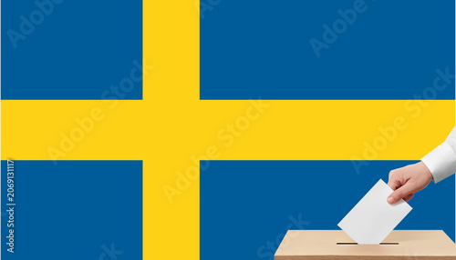 Fotografija Sweden general elections 2026 concept with voter hand putting ballot paper in box over swedish flag background