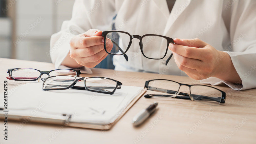 Fototapeta premium Ophthalmologist offers glasses to patient