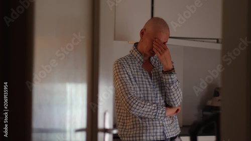 Female cancer patient standing alone in kitchen during recovery journey, highlighting emotional strain, resilience, uncertainty, reflection and personal strength