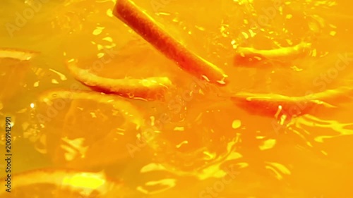 close up of natural orange slices falling in juice, advertising of tropical fruit juice splashing, super slow motion
