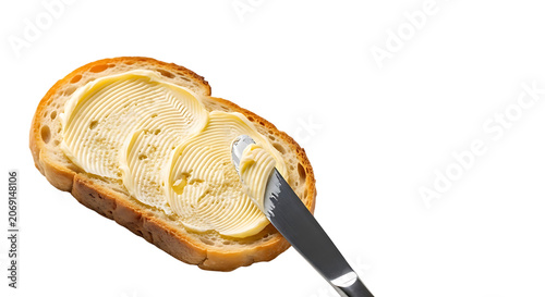 Slice of bread with butter and a butter knife on a black background