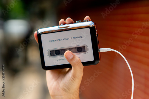 Hand holding a walkman. A device for listening to old music stored on cassettes.
