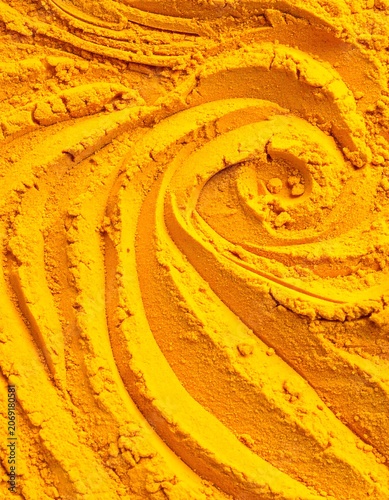 Vibrant yellow powder swirl texture close up abstract