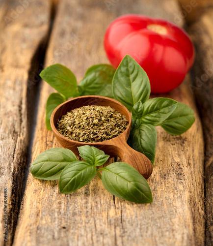 Basil  fresh  leaves with  dry spice  on wooden background. Tomatoe with spice.