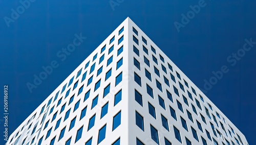 Angular modern white building against a stark blue gradient sky with grid